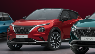 Red Nissan Juke center stage with a blue compact and a teal Qashqai beside it in a showroom lineup.