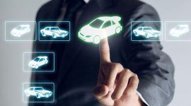 Person in a suit taps a green-highlighted car icon on a futuristic touchscreen to select a vehicle