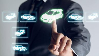Person in a suit taps a green-highlighted car icon on a futuristic touchscreen to select a vehicle