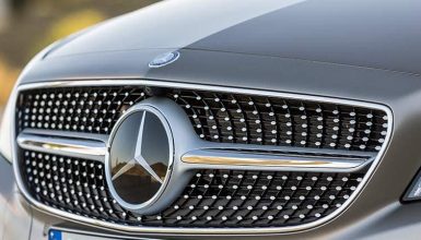 Close-up of a silver Mercedes-Benz car grille with the emblem visible in the center